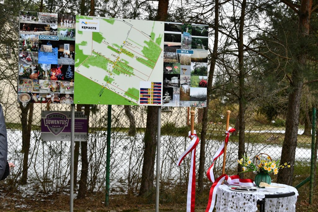 tablica ze zdjęciami ze wsi Kępiaste oraz przebiegiem wyremontowanej drogi